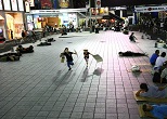 新宿コマ劇場前広場でかけっこをする小学生のショウタロウ君とミミちゃん。二人は週に何度か親とやってきて、遅くまでお絵書きなどをして遊んでいた。2008年７月
