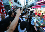 韓流ショップ前で抗議の声をあげる反韓デモの参加者たち。2012年８月