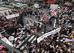 職安通をデモ行進する嫌韓派を取り巻いて反差別を訴える人々。2013年６月