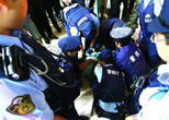 暴れていた男性が、警官たちに取り押さえられた。2008年８月