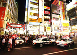 パトカーが駆けつけ、さらに多くの人々でごったがえす歌舞伎町一番街入口。2008年８月