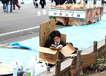 場所取りは若手社員の「仕事」。寒さはダンボールでしのぎ、読書で時間をつぶす。2009年、上野公園の花見