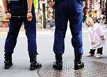 警戒中の警官たちを興味深げに見上げるあんじゅちゃん（２歳）。歌舞伎町コマ飲食店街にあった雑貨店のお孫さんだ。2008年６月