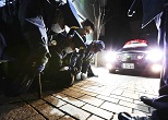 パトカーのライトが取り押さえられた刃物男を照らし出す。2013年１月