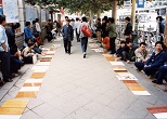 歩道上に自分自分の特技を書いた紙を並べ、職を求める男たち。1992年９月、大連駅近く