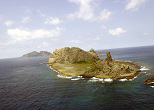 尖閣・南小島。後方に見えるのは魚釣島。2002年