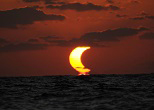 部分日食したまま太陽が沈む「金環部分日食」。座間味島沖でクジラを撮影中に出会った。真っ赤で大きな三日月が沈んでいく光景は、神秘的だった。2010年１月15日